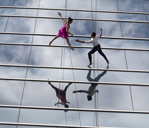 Two people dancing on the side of a building.