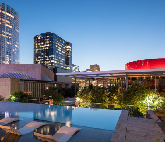 Hall Arts Residences pool deck with city view of Winspear Opera House.